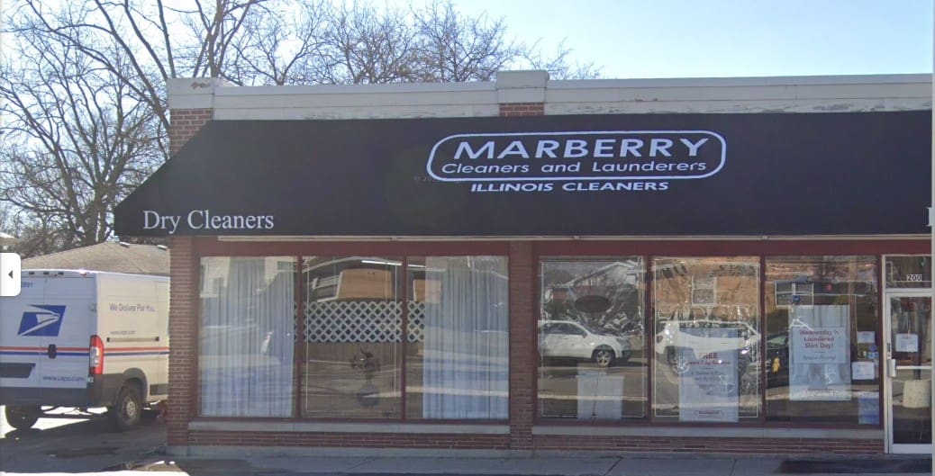 Street view of a dry cleaners shop named "Marberry Cleaners and Launderers" with a USPS mail van parked outside.