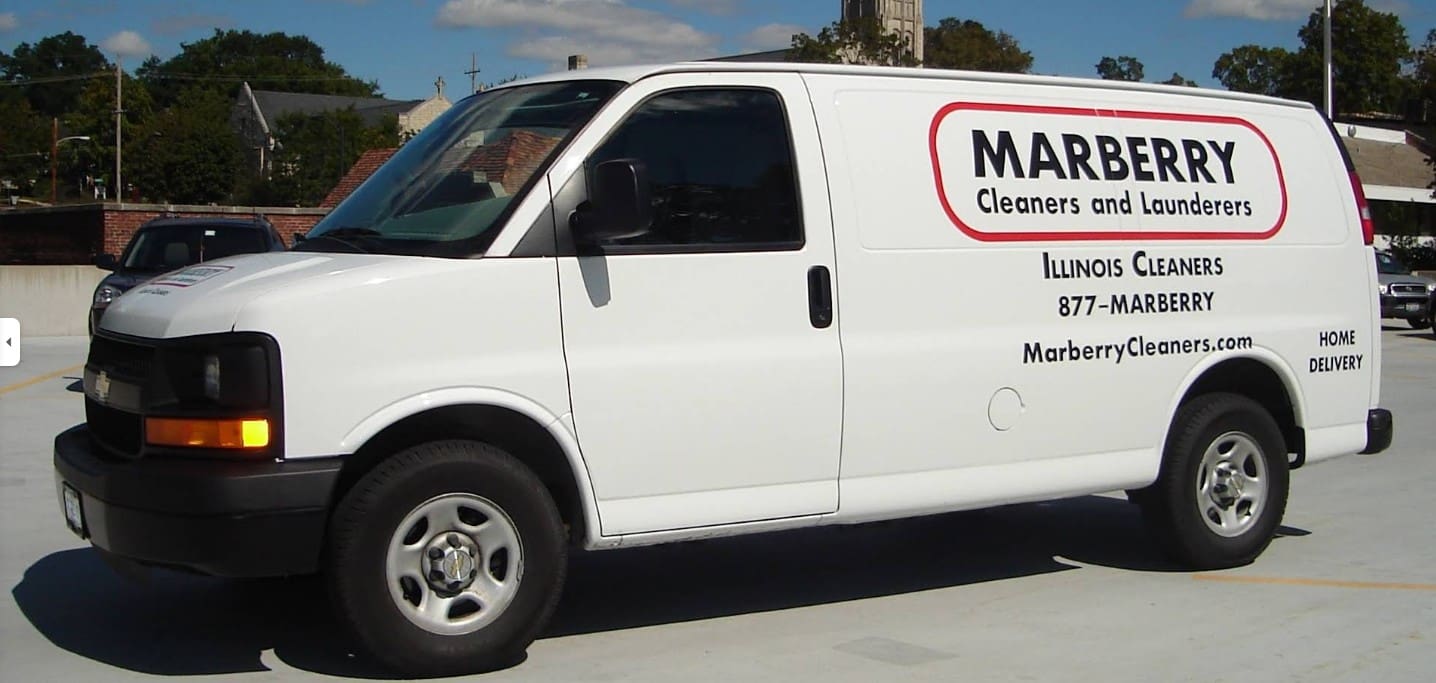 A white van with "Marberry Cleaners and Launderers" and contact information printed on the side, parked in an outdoor lot.